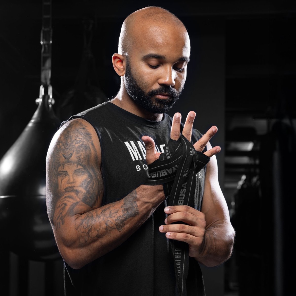 Înfășurat manual și protejat de bandajul realizat cu bandaj elastic Mayweather Hayabusa de 180 inch negru și gri, cu închidere cu cârlig și buclă Secured poziționată pe încheietura mâinii