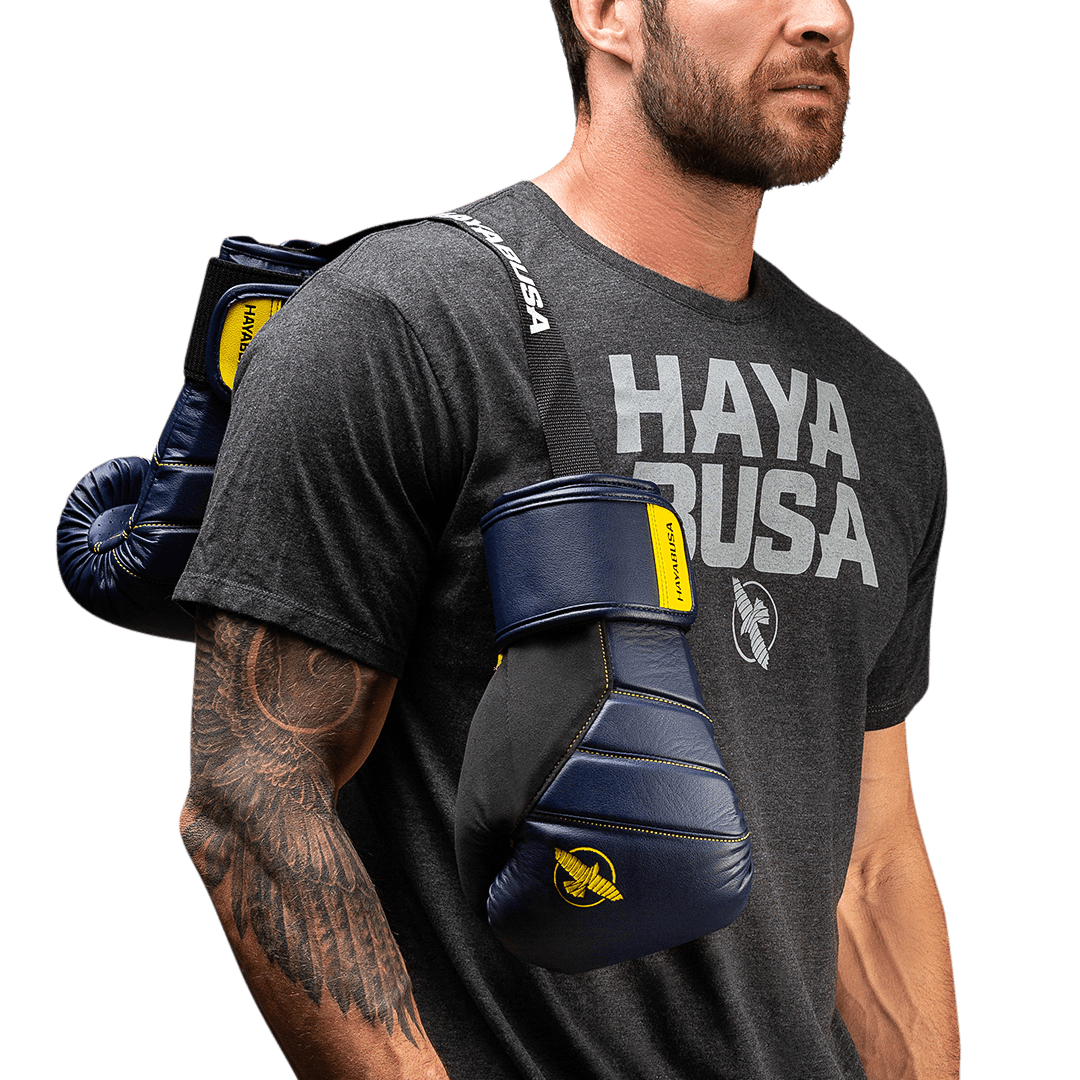 Primo piano di guantoni portati a spalla con il deodorante Hayabusa nero visibile all'interno del polsino