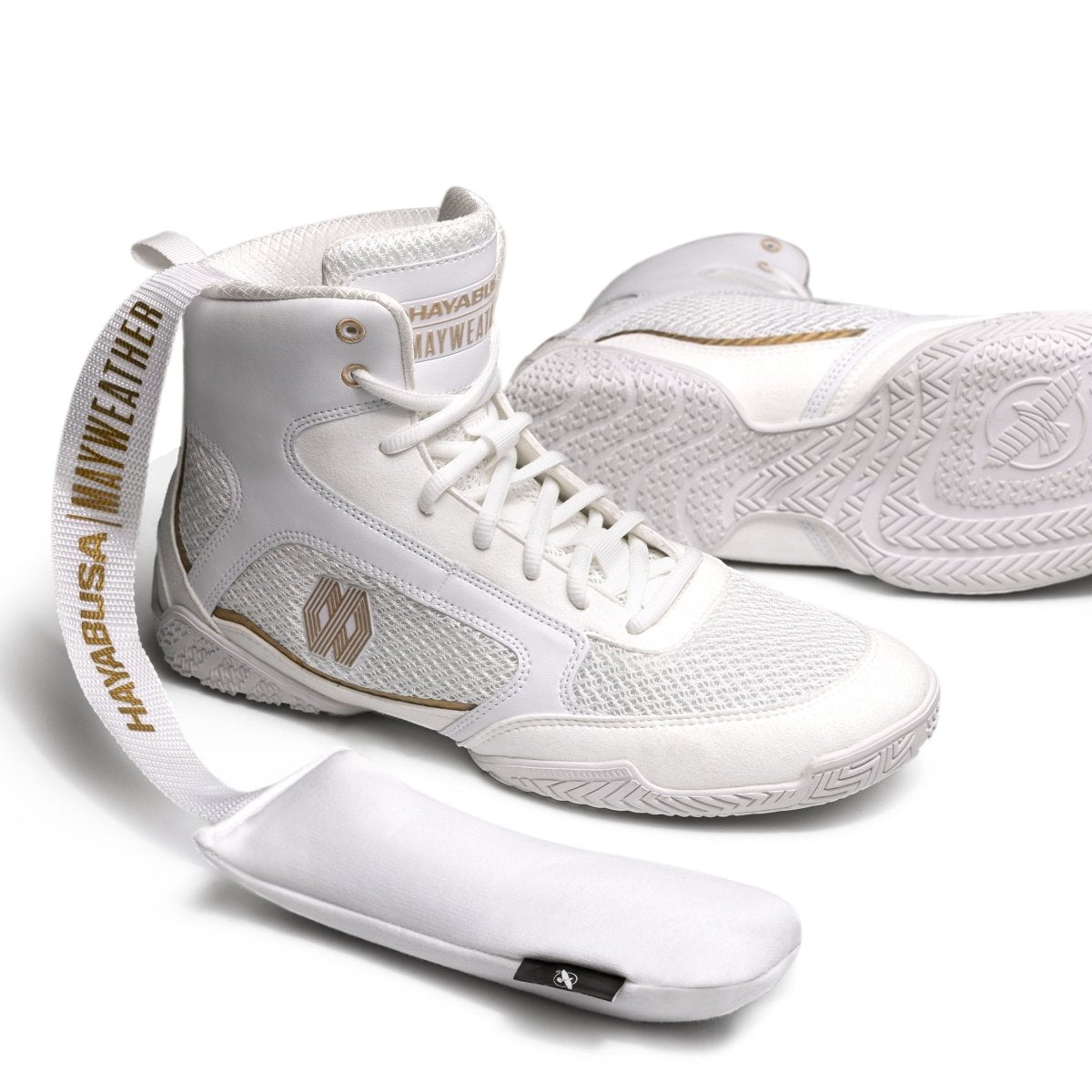 Desodorante Mayweather de carbón de bambú blanco y dorado colocado dentro de zapatos de boxeo