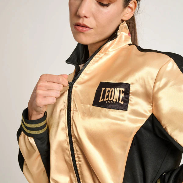 Dettaglio ravvicinato del logo nero Leone 1947 applicato sulla finitura lussuosa in raso oro