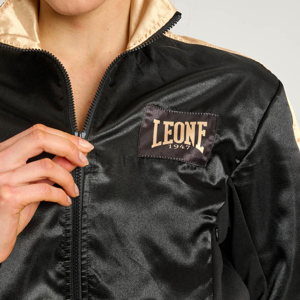 Primo piano del logo dorato Leone 1947 ricamato sul petto della felpa corta nera linea DNA