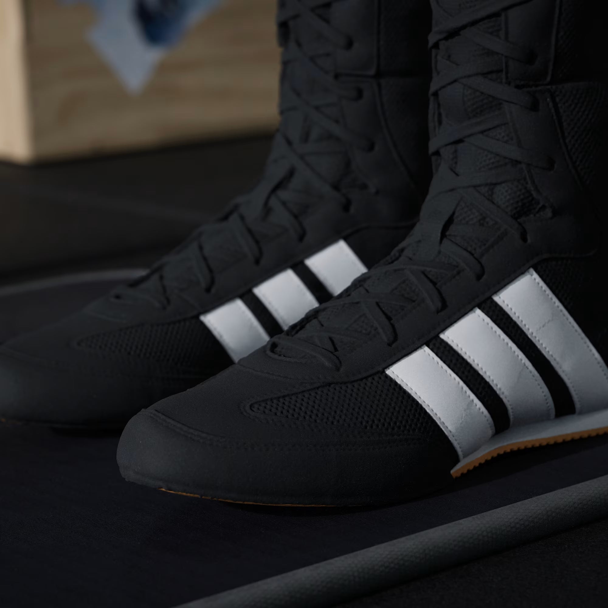 Primo piano della tomaia in mesh traspirante delle scarpe da boxe leggere Adidas.