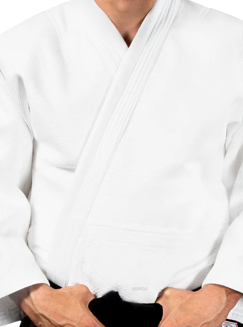 Dettaglio dei rinforzi sulle spalle e del bavero robusto della giacca Judogi Daedo Elite bianca.