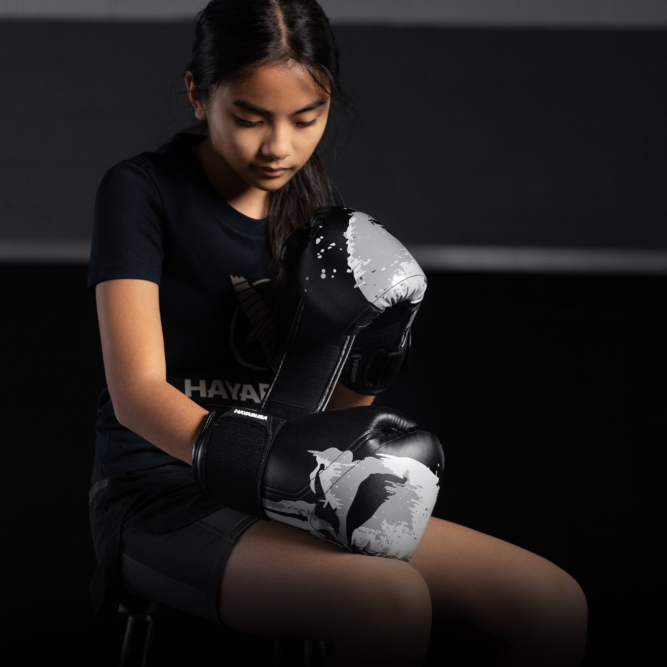 Una bambina che indossa i guantoni da boxe neri Hayabusa Marvel Punisher in posizione di guardia