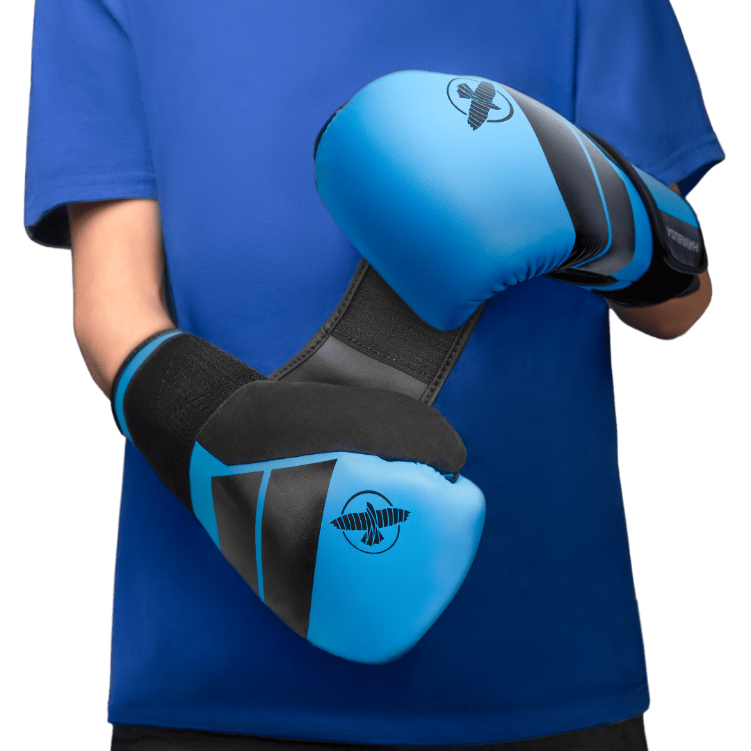 Un enfant portant les gants bleus Hayabusa S4 en position de garde