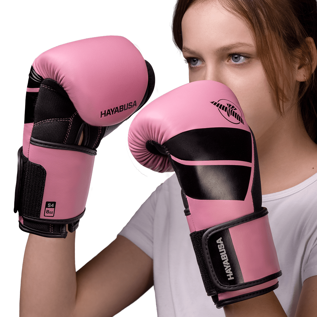 Petite fille avec les gants roses Hayabusa S4 portés pour frapper le sac