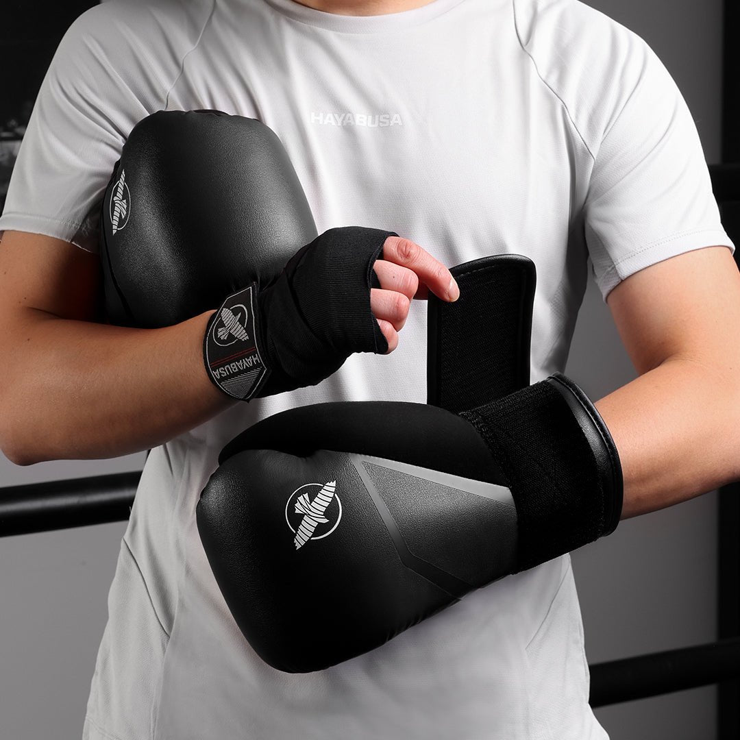 Aufnahme der schwarzen Hayabusa E1-Boxhandschuhe, die ein Kämpfer trägt