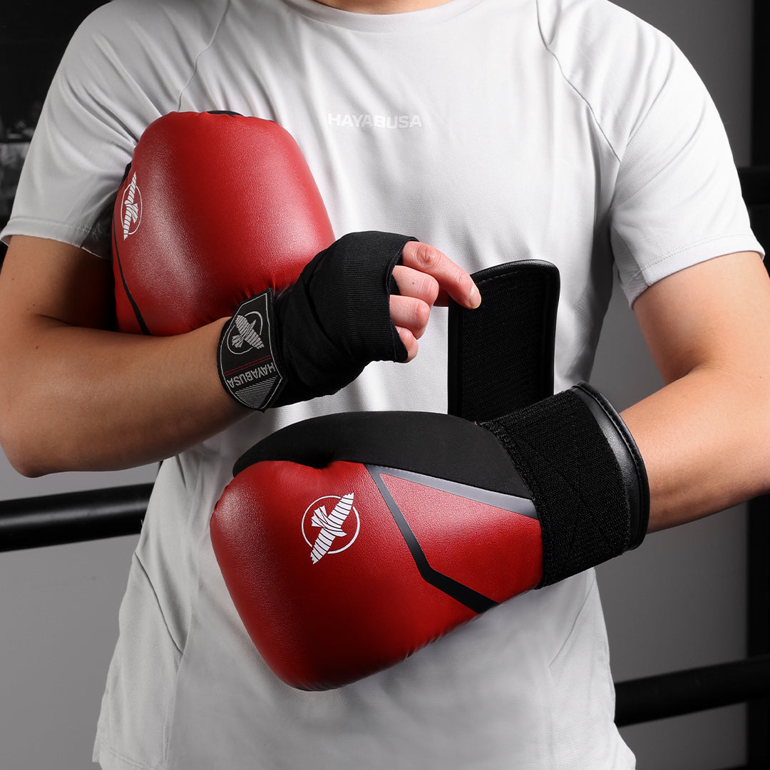Sportler mit roten Hayabusa E1-Boxhandschuhen in beeindruckender Aktion