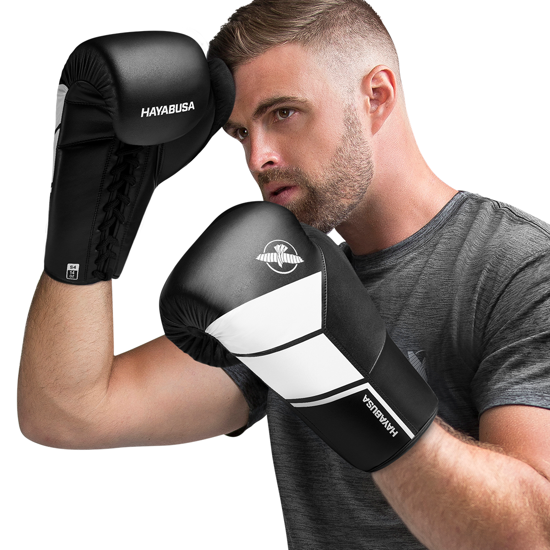 Atleta che indossa i guantoni neri Hayabusa S4 con lacci durante una sessione di allenamento professionale