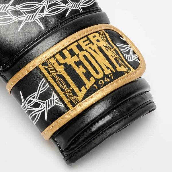 Dettaglio macro della patch tessuta in oro LEONE x IUTER sulla chiusura a velcro