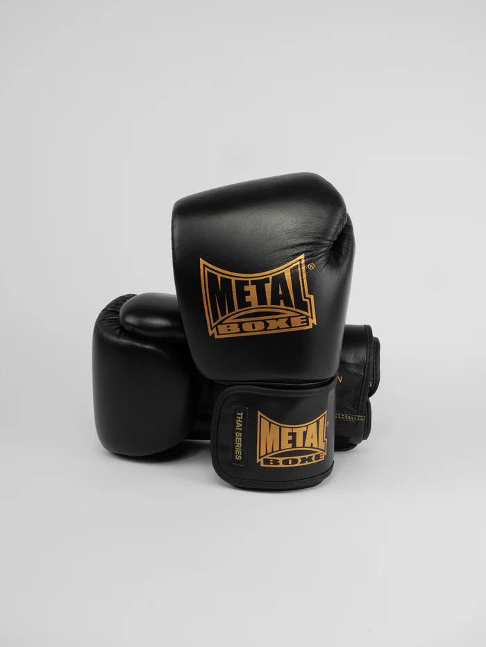 Framifrån av Metal Boxing Thai Series handskar i svart och guld fullnarvsläder