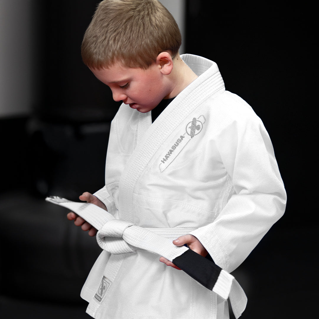 Un bambino che si allena sul tatami indossando il kimono BJJ Hayabusa Essential bianco