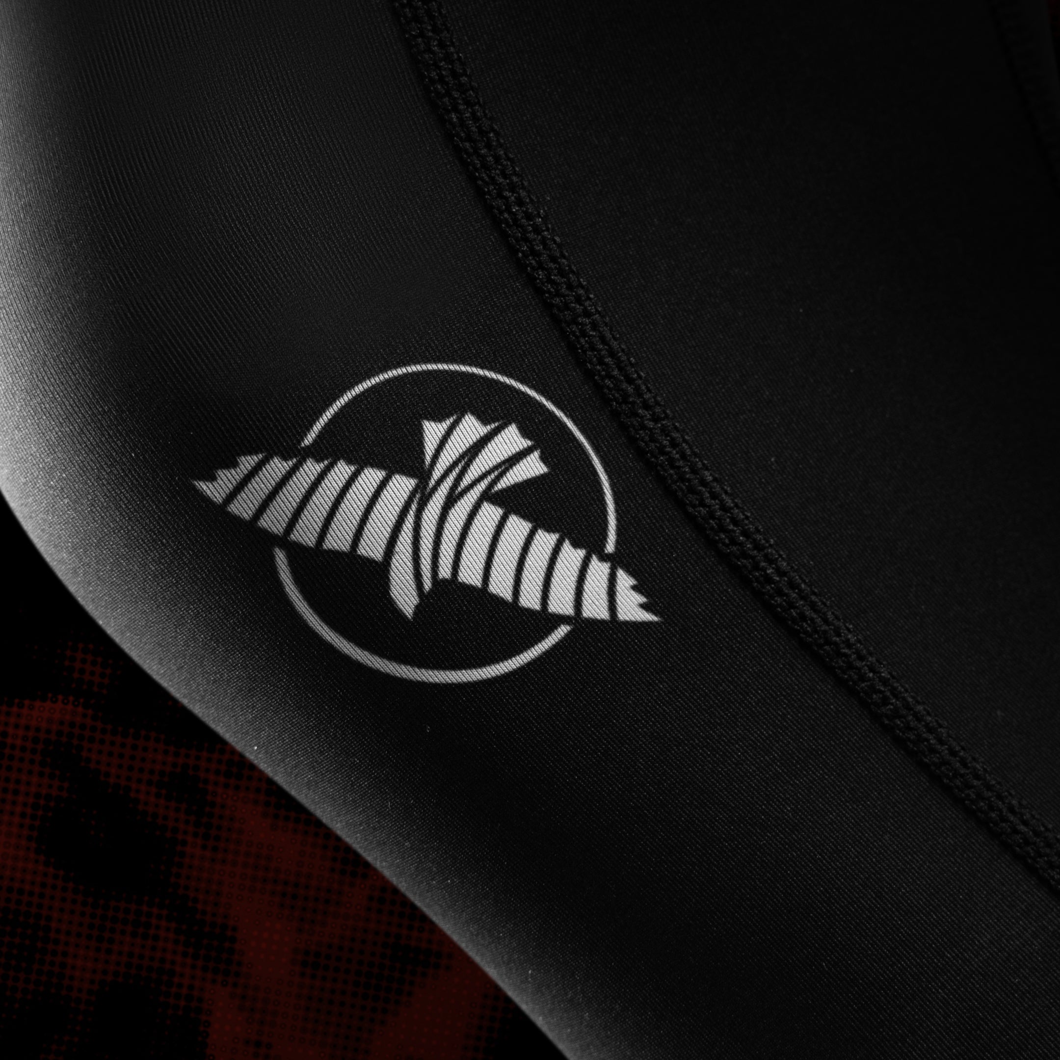 Primo piano del logo ufficiale UFC e della grafica stampata sulla gamba dei leggings donna BJJ neri e rossi