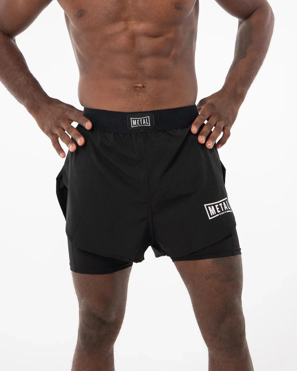 Vista frontal de unos pantalones cortos negros 2 en 1 Metal Boxe usados por un atleta