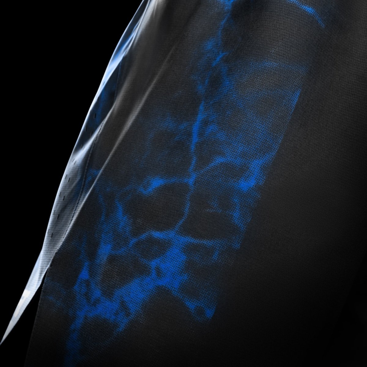 Die Seitenansicht der schwarz-blauen UFC BJJ-Shorts hebt das leichte und atmungsaktive technische Gewebe hervor