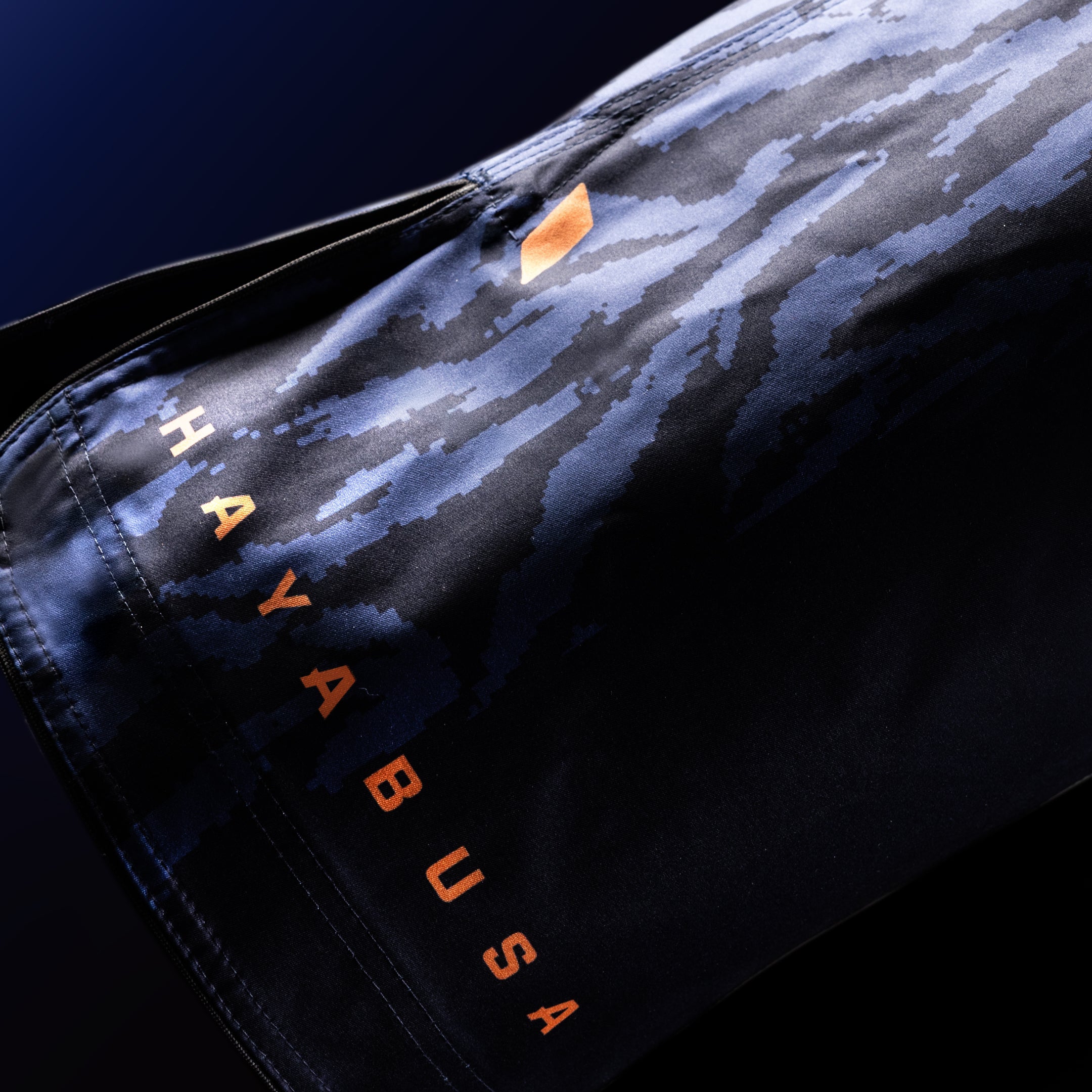 Primo piano della scritta ufficiale Hayabusa stampata sulla gamba dei pantaloncini blu da combattimento