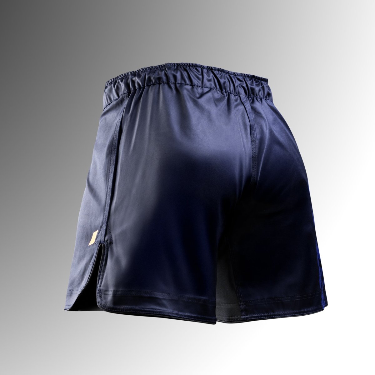 Vedere din spate a pantalonilor scurți albaștri Hayabusa Apex Mid-Thigh MMA, arătând centura sigură și materialul rezistent la rupere