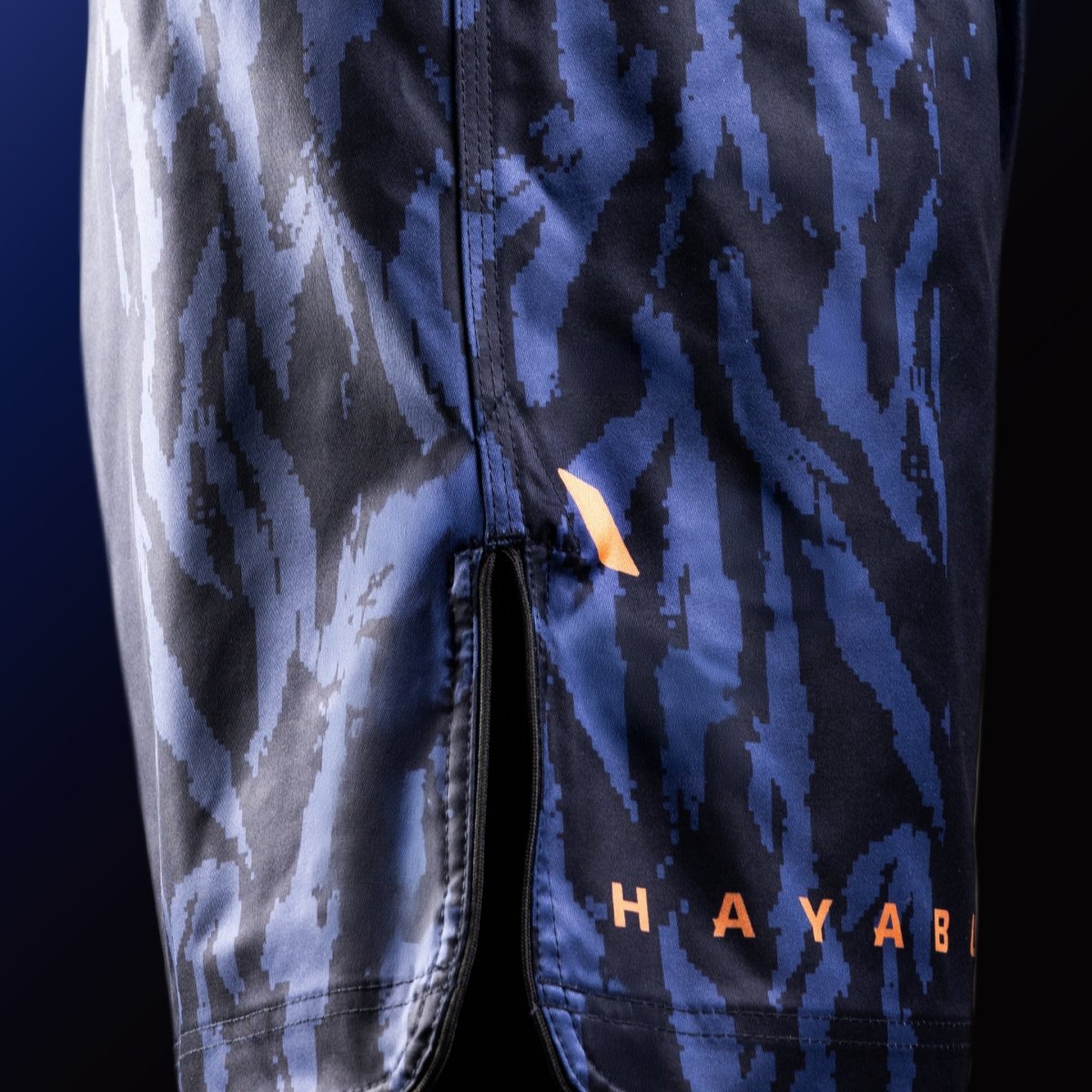 Vedere laterală a pantalonilor scurți albaștri Hayabusa Apex Mid-Thigh MMA cu detaliu de aerisire pentru mobilitate maximă