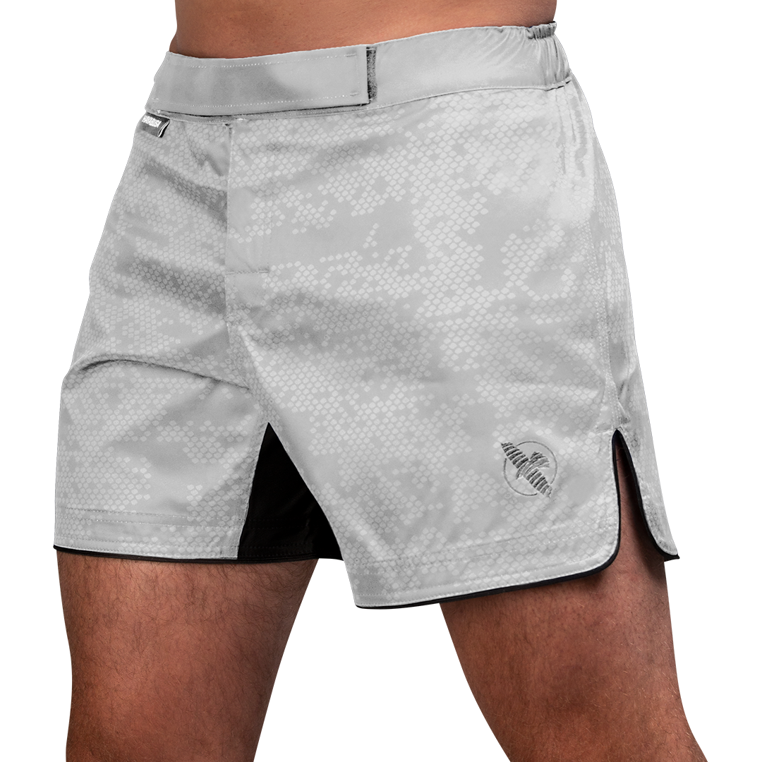 Vista frontale dei pantaloncini MMA Hayabusa Hex Mid-Thigh bianchi, design ibrido versatile per training