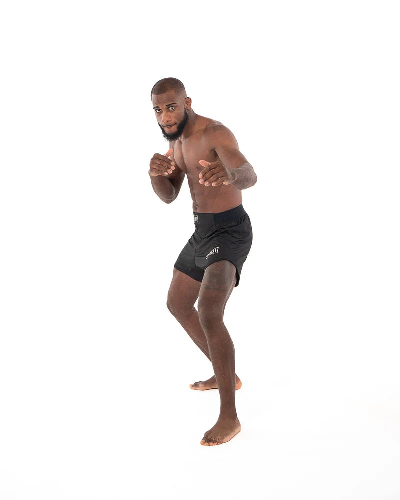 Vista lateral de pantalones cortos de boxeo MMA Metal negros con detalle de inserción elástica interna en la pierna