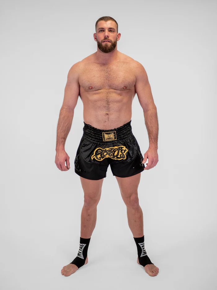 Detalj av det tekniska tyget och finishen på de svarta Metal Boxing Muay Thai-shorts för män