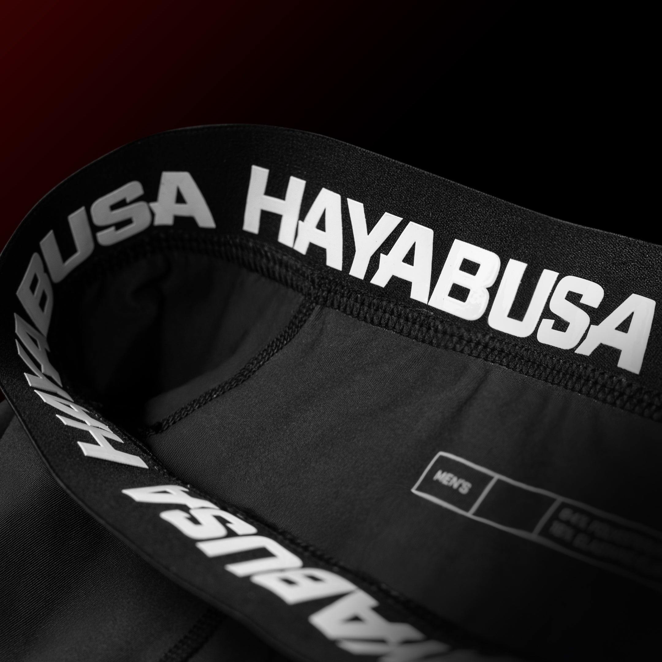 Dettaglio del girovita con grip in silicone dei pantaloncini ufficiali UFC BJJ rossi e neri