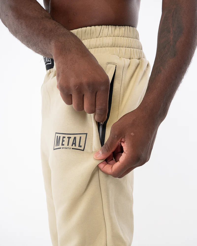 Dettaglio cintura arricciata e tasca con zip invisibile pantaloni tuta Metal Boxe beige