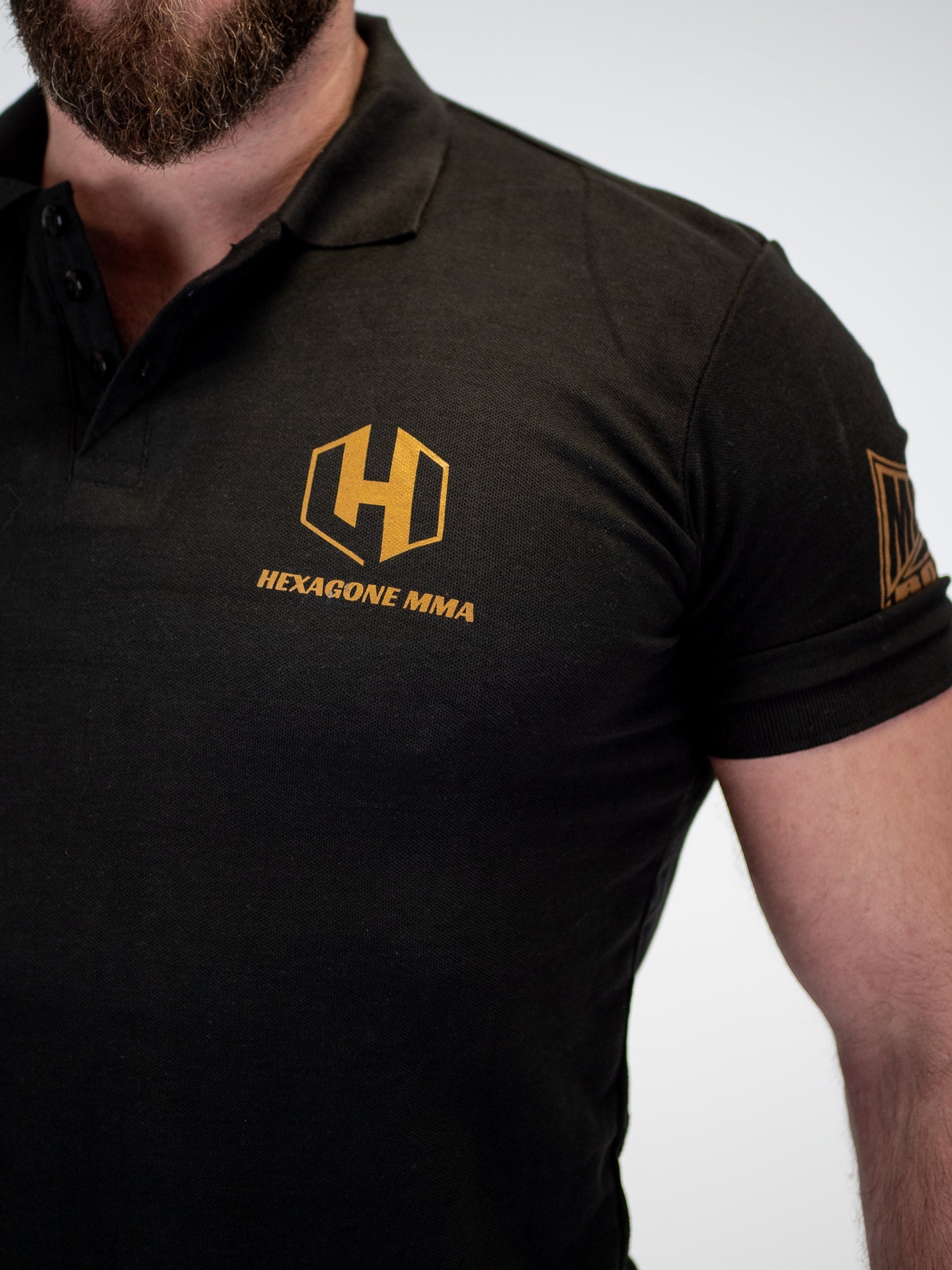 Dettaglio del colletto e del ricamo logo Hexagon MMA sulla polo Metal Boxe nera