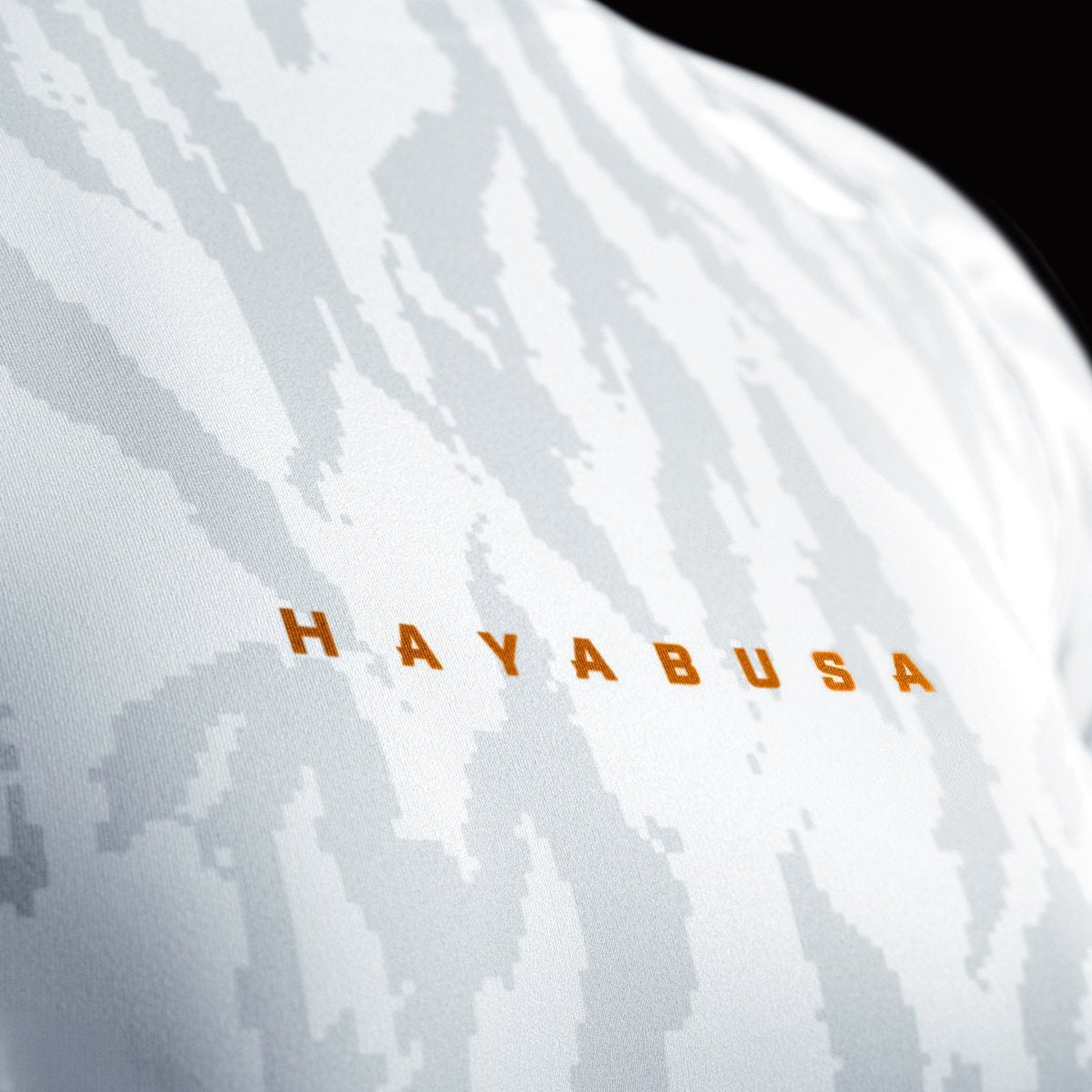 Close-up van de Hayabusa-print op de voorkant op de witte rashguard voor dames, detail van de kraag met gebonden naden