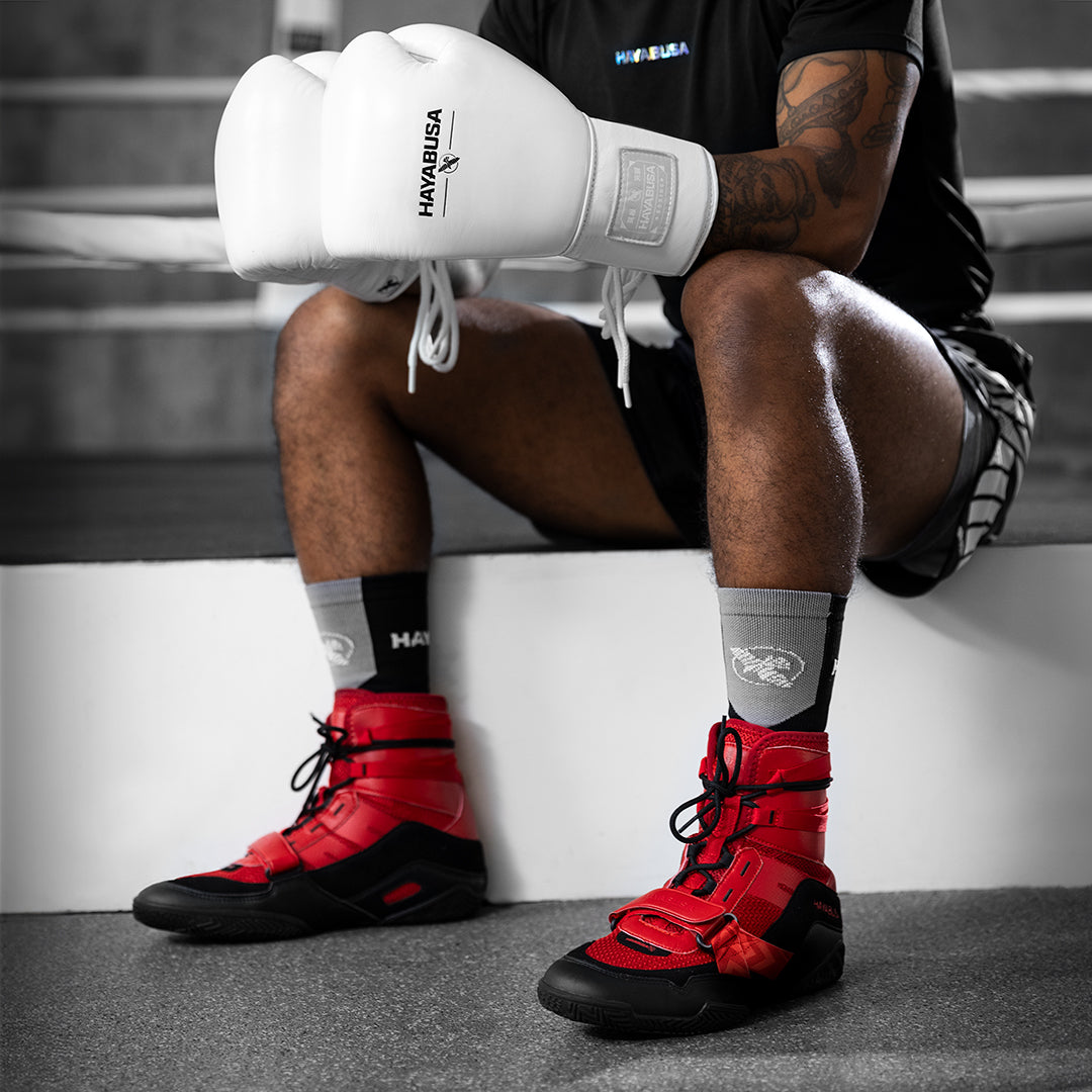 Calzata delle scarpe da boxe rosse Hayabusa Strike su un pugile pronto al match