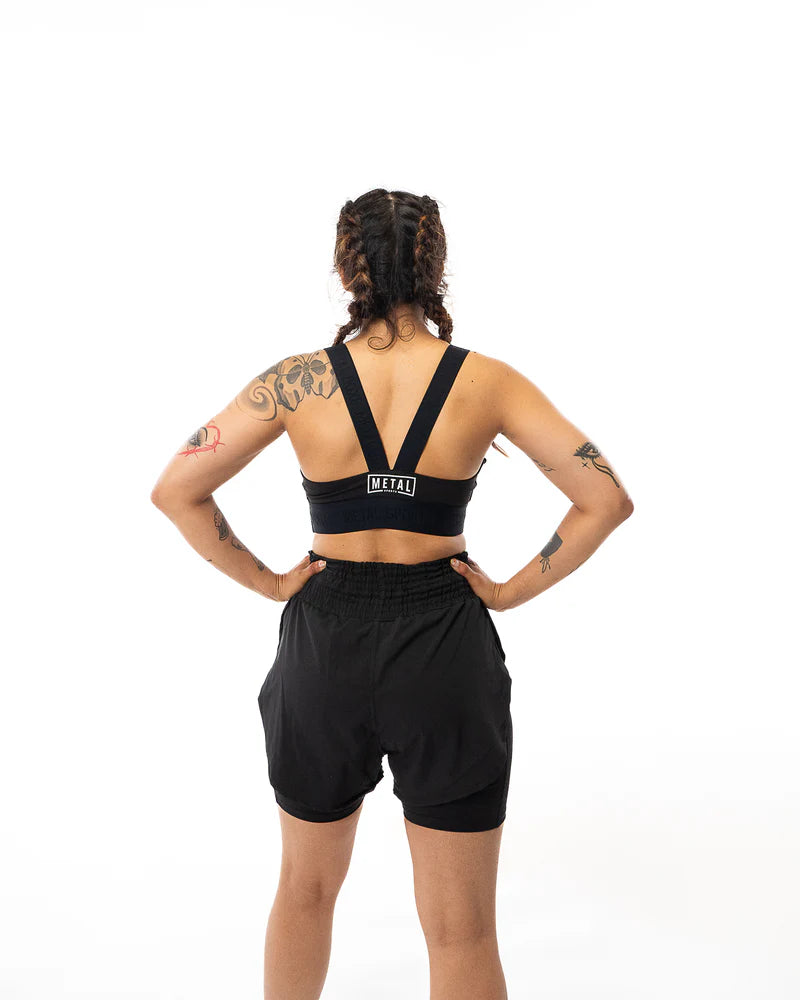 Vista posteriore della brassière Metal Boxe Desert Storm nera, dettaglio incrocio e supporto