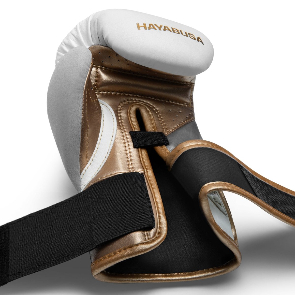 Détail des bretelles Dual-X ouvertes des gants blanc et or