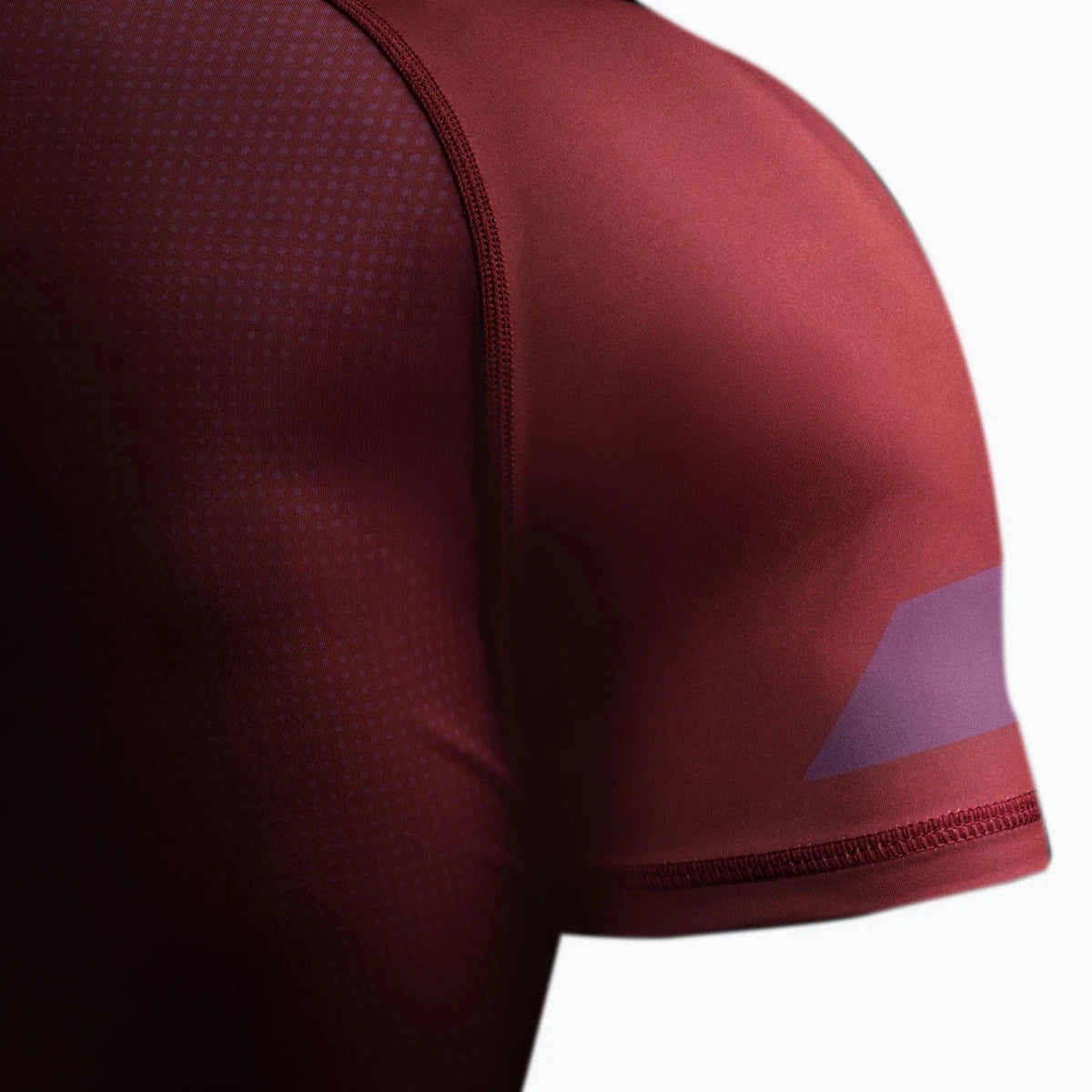 Detail der rutschfesten Silikonkante am burgunderroten Rashguard.