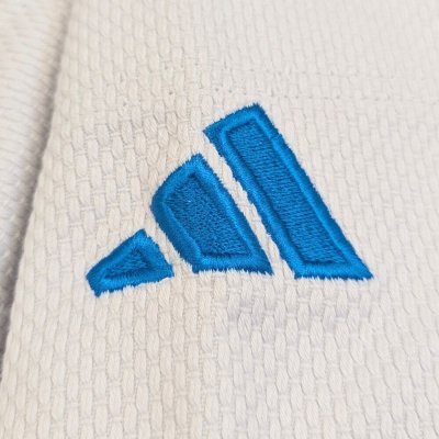 Particolare delle tre strisce Adidas e del logo azzurro versione Italia sulla spalla del judogi