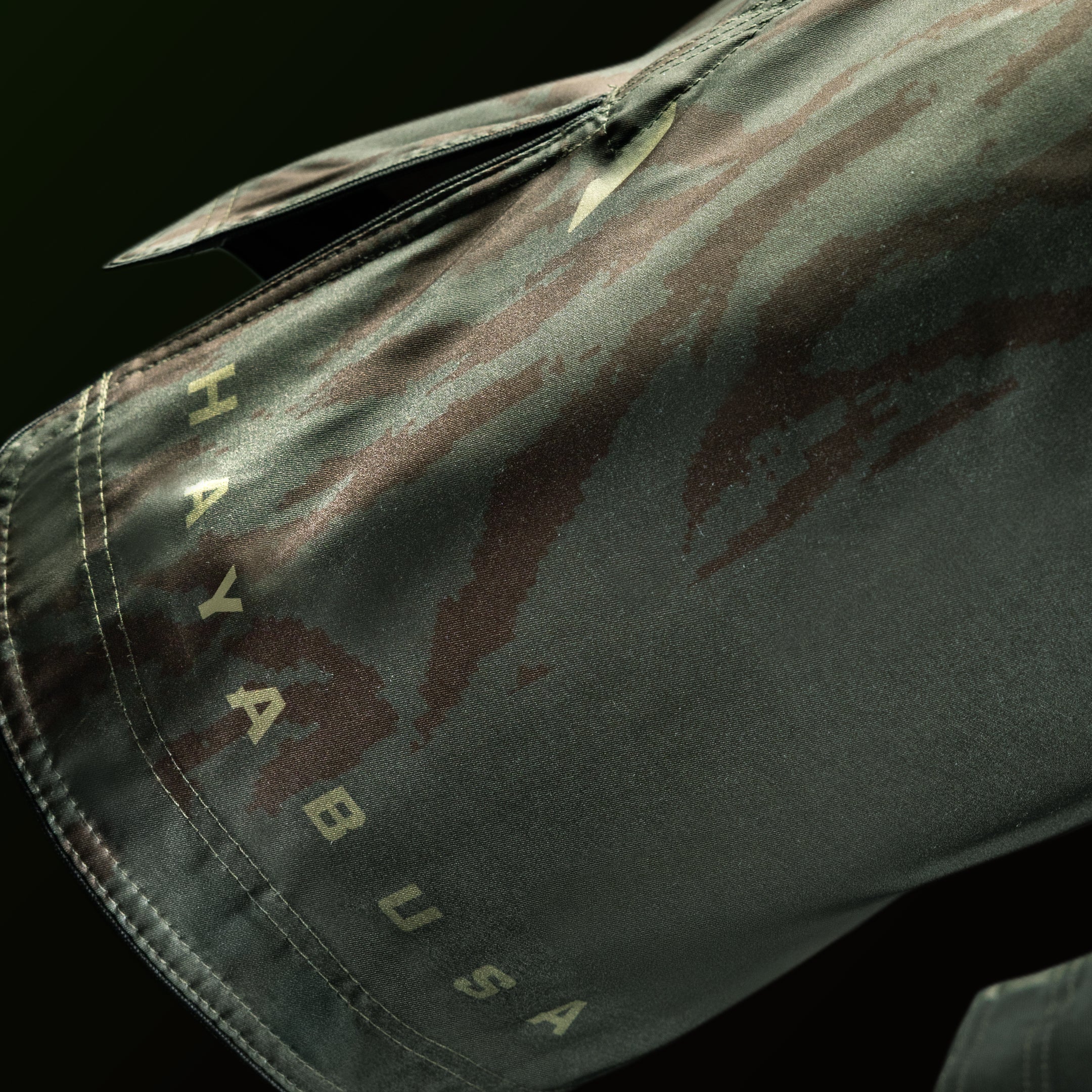 Dettaglio del logo e della scritta Hayabusa stampati sulla gamba dei pantaloncini verdi a lunghezza intera