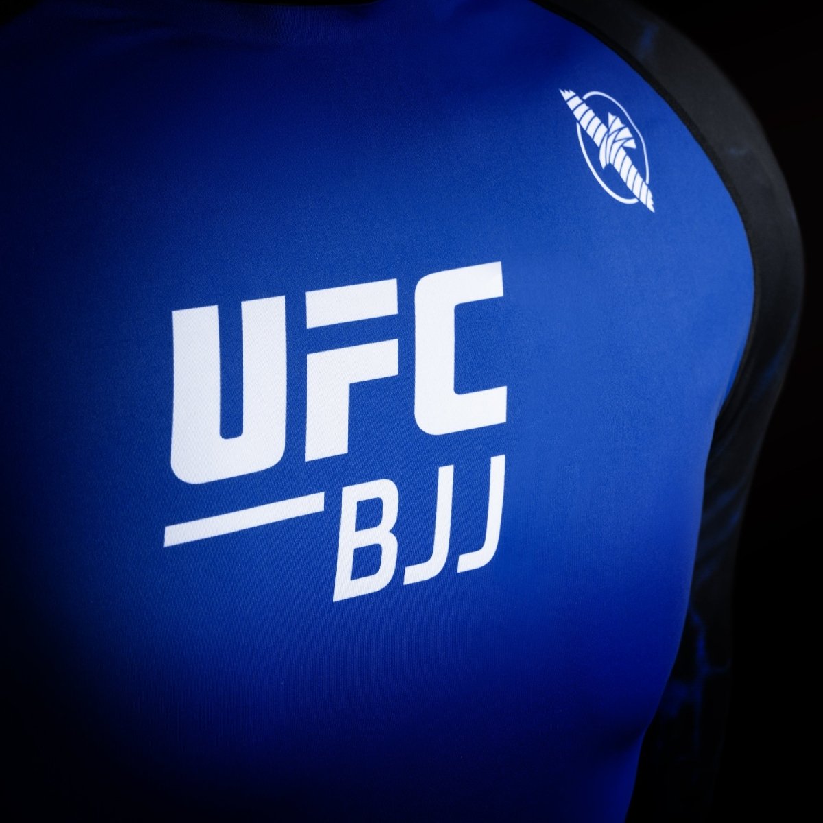 Détail du logo UFC sur le lycra de compétition noir et bleu, détail du tissu haute résistance