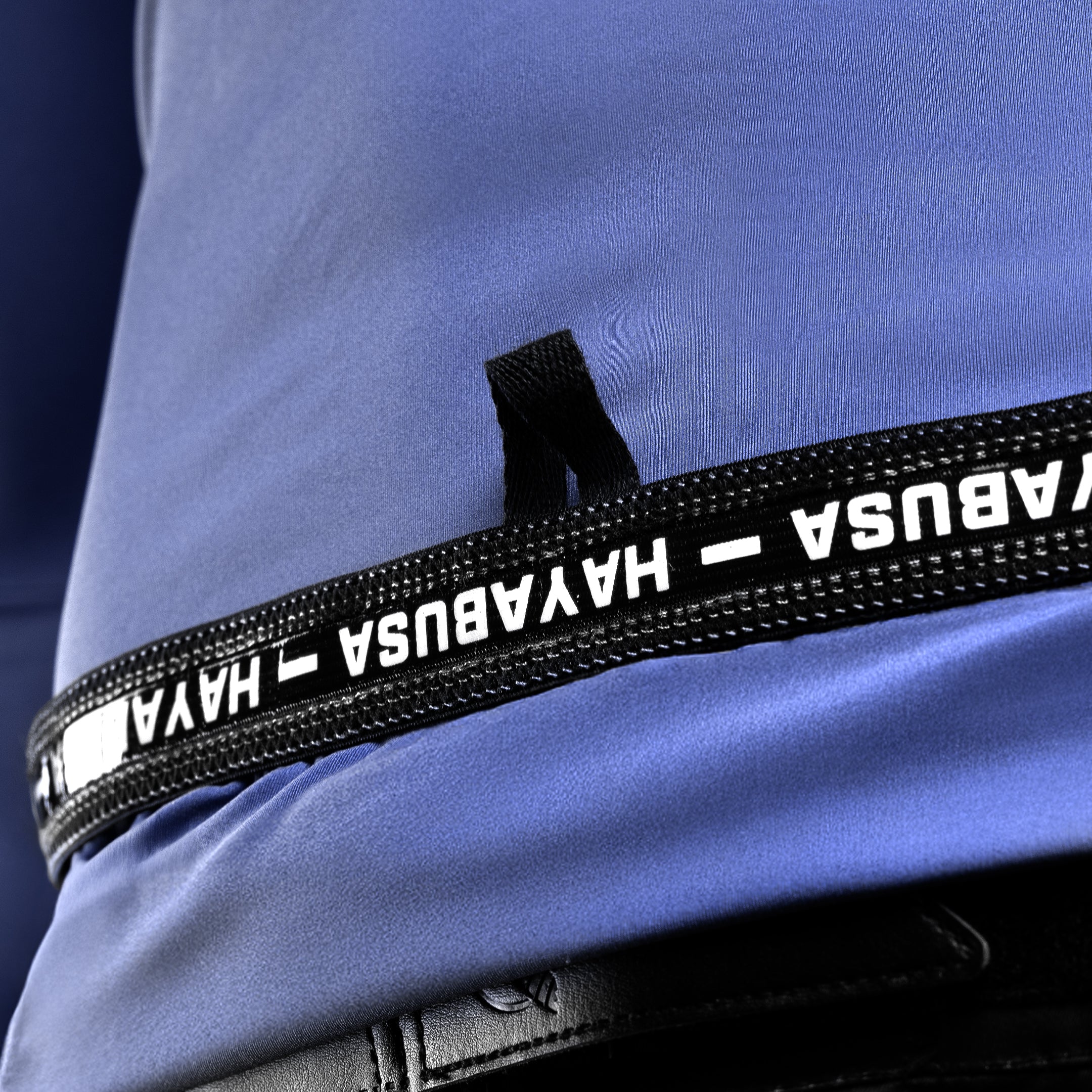 Primo piano della stampa interna con le istruzioni di cura e il branding sulla rashguard blu