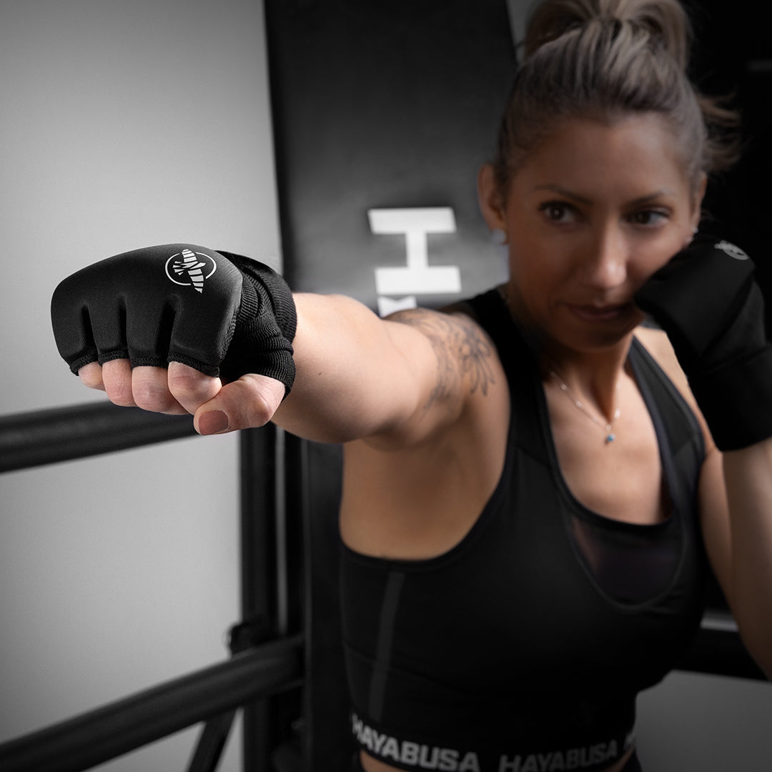 Sottoguanti neri Hayabusa Elite indossati da una donna che mostrano il fit delle dita e la chiusura al polso