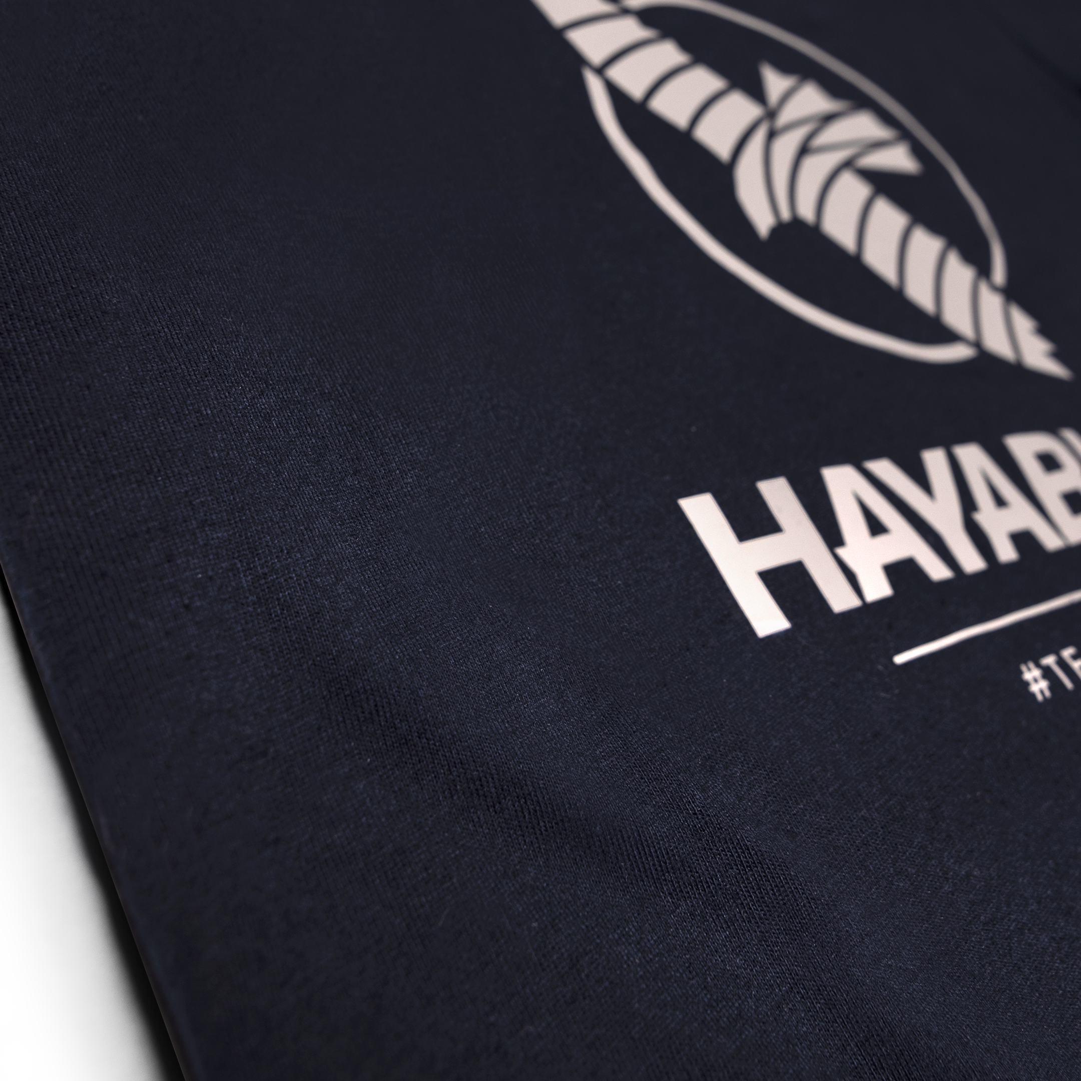 Primo piano della grafica Team Hayabusa in silicone sulla t-shirt color blu notte